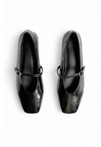 Un paio di scarpe Mary Jane nere e lucide con punte quadrate e sottili cinturini a fibbia, esposte affiancate su uno sfondo bianco.