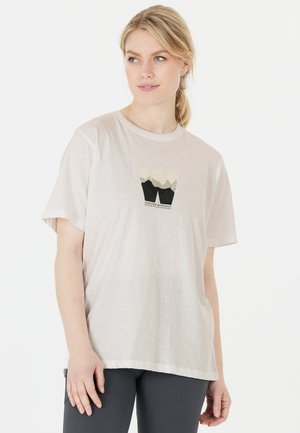 Licht beige t-shirt met korte mouwen van een zachte stof, met een bergafbeelding in tinten groen en zwart op de voorkant.