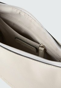 Clutch bag in pelle bianca testurizzata con chiusura a zip. L'interno presenta una tasca con zip e una tasca a soffietto, entrambe in tessuto chiaro.