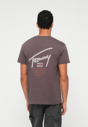 Καφέ βαμβακερό T-shirt με λευκό γραφικό λογότυπο στην πλάτη, που περιλαμβάνει ονόματα πόλεων και λεπτομέρειες. Κοντά μανίκια, με σχέδιο crew neck.