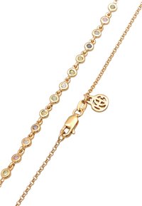 Guldtonet halskæde med cirkulære ædelsten i forskellige farver, en klo-lås og en dekorativ logo vedhæng.