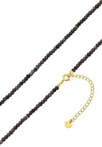 Naszyjnik z czarnych fasetowanych koralików z złotymi akcentami. Posiada zapięcie typu lobster oraz regulowany łańcuszek umożliwiający dostosowanie długości.