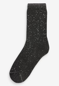 Chaussettes noires en tissu doux, présentant un motif tacheté de points blancs et gris, avec une bordure côtelée et un orteil renforcé.