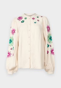 Kremfarget skjorte med rund hals, lange puffede ermer og livlig blomsterbroderi i rosa og grønt på skuldrene og ermene.