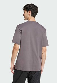 T-shirt grigio a maniche corte realizzato in cotone, presenta un semplice design con scollatura a girocollo e una vestibilità comoda, vista da dietro.