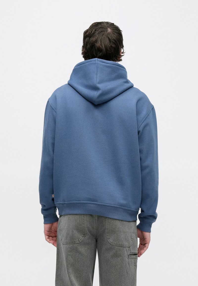 Felpa blu con cappuccio in tessuto morbido, dotata di tasca a marsupio e polsini a costine, abbinata a pantaloni grigi. Design semplice senza motivi.