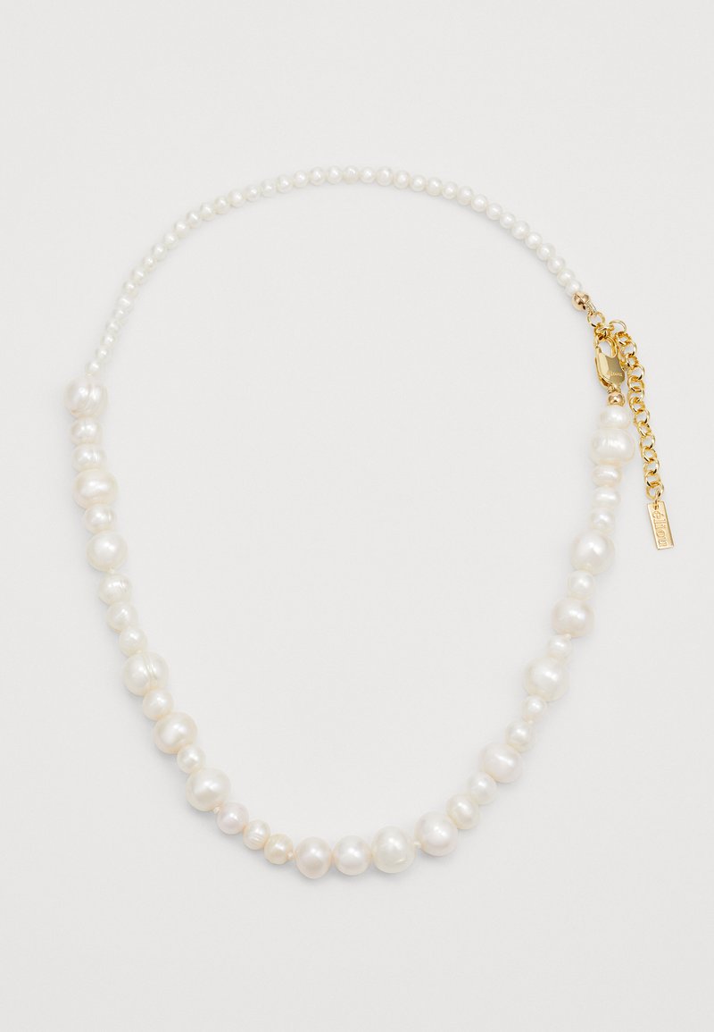 Collana multicadente con perle bianche irregolari e piccole perline rotonde. Accessori in tonalità oro con chiusura a gancio e una targhetta decorativa.