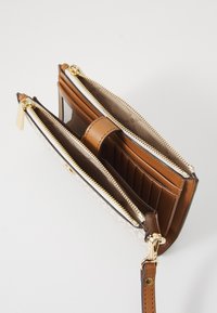 Portafoglio in pelle marrone con un esterno testurizzato di colore chiaro. Presenta due scomparti con zip, diverse fessure per carte e una tracolla.