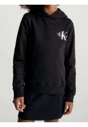 Zwarte capuchontrui met geribbelde manchetten en zoom, met een wit Calvin Klein Jeans-logo aan de linkerbovenkant. Gladde stoftextuur.