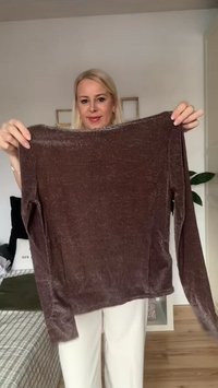 Långärmad topp i mörkbrunt, gjord av mjukt, något glansigt tyg. Har en lös passform och rund halsringning, med en slät textur.