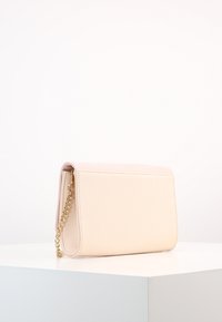 Ljusrosa faux läderaxelväska med en guldkedjesnodd, rektangulär form, slät yta och minimalistisk design.