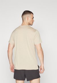 Puma TRAIN CAT TEE - Spordi T-särk - putty heather