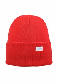 Red knit beanie hat with a folded cuff, made of soft material. Features a small white label with blue lettering on the front.