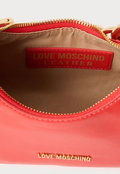 Червена кожена чанта Love Moschino с златен цип и златно лого на външната страна и червен вътрешен етикет с надпис "LOVE MOSCHINO LEATHER."