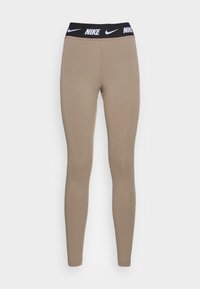 Beige leggings met een zwarte elastische tailleband met het Nike-logo. Zacht, rekbaar materiaal met een getailleerd ontwerp.
