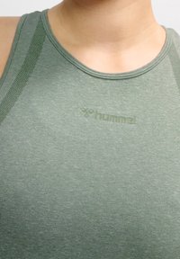 Light green athletic tank top with a round neckline, featuring subtle texture and a logo printed in a slightly darker shade.