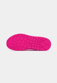 Bright pink rubber shoe sole featuring a textured tread pattern with geometric shapes for enhanced grip and traction.