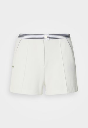 Pantaloncini bianchi con una fascia in vita a righe blu navy, caratterizzati da pieghe, tasche laterali e un piccolo logo verde accentuato sul davanti.