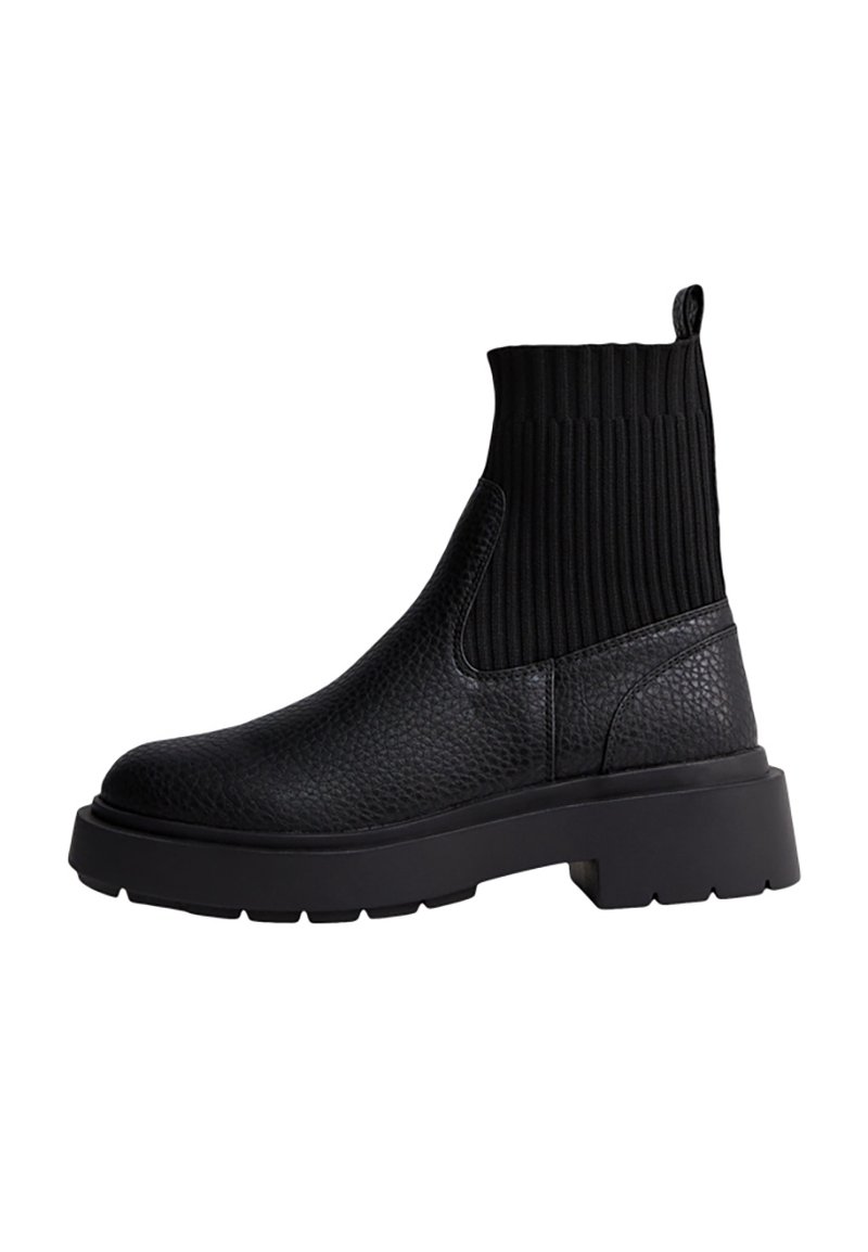 Stivaletti neri alla caviglia con tomaia in pelle strutturata e colletto in maglia a coste. Suola in gomma spessa per durabilità e maggiore altezza.