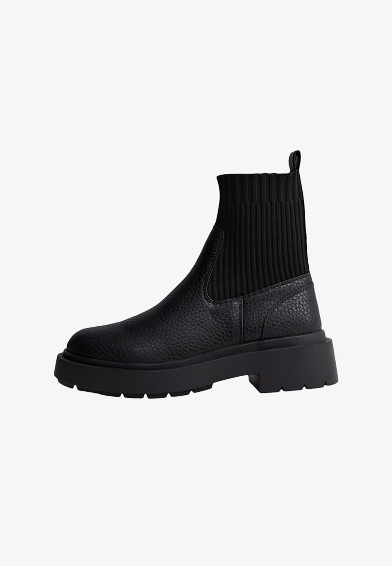 Stivaletti neri alla caviglia con tomaia in pelle strutturata e colletto in maglia a coste. Suola in gomma spessa per durabilità e maggiore altezza.