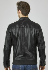 Schwarze Lederjacke mit glatter Textur, Rippensaum und detaillierter Steppung; verfügt über einen klassischen Kragen und eine taillierte Silhouette.