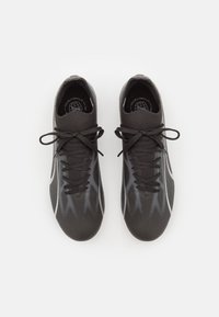 Scarpe sportive nere con una tomaia texture, caratterizzate da motivi zigzag grigi e lacci neri, progettate per alte prestazioni e supporto.