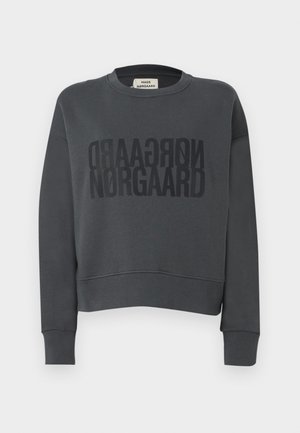 Siva jopa z krajšo zasnovo, okroglim izrezom in velikimi črnimi črkami "NØRGAARD" močno odtisnjenimi na sprednji strani.