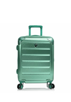 Maleta de tamaño mediano de color verde metálico con carcasa rígida, asa telescópica y cuatro ruedas multidireccionales, colocada de pie sobre un fondo blanco.