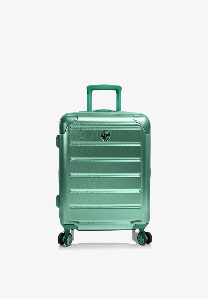 Valise rigide de taille moyenne, métallique verte, avec poignée télescopique et quatre roues multidirectionnelles, debout sur fond blanc.