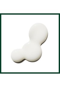 Weißer Lotion- oder Creme-Fleck mit drei verbundenen abgerundeten Bereichen auf weißem Hintergrund mit dunkelgrünem Rand.