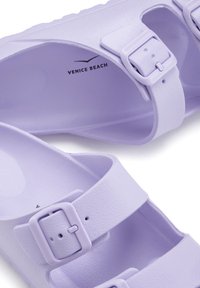 Sandales en plastique violettes avec deux boucles réglables, des sangles texturées et un rembourrage anatomique ; présente l'inscription "VENICE BEACH" à l'intérieur.