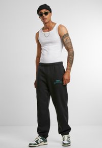 Upscale by Mister Tee Teplákové kalhoty - black