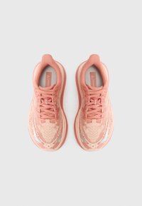 Baskets de sport roses avec un dessus en mesh texturé, fermeture à lacets, col rembourré et semelle amortissante. Présente un motif subtil.