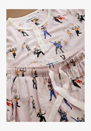 Katoenen pyjama set met een lichtroze achtergrond en een skaterprint. Het bovenstuk heeft een knoopsluiting en de broek heeft een elastische tailleband.