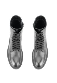 Bottines en cuir noir avec une texture lisse, dotées d'un système de laçage à l'avant et d'une fermeture éclair sur le côté pour un enfilage facile.