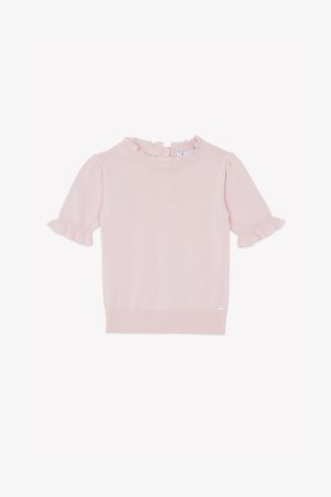 Maglioncino rosa chiaro a maniche corte con scollo e bordi delle maniche arruffati, orlo a coste e piccolo logo decorativo sul lato inferiore.