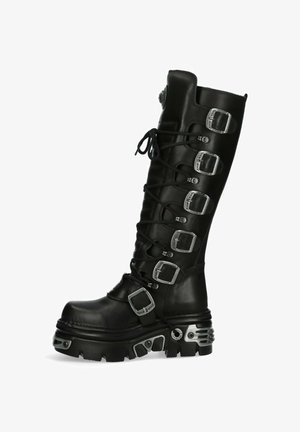 Bottes noires jusqu'aux genoux avec plusieurs boucles en argent, en cuir texturé, à lacets à l'avant, bout arrondi et semelle épaisse et robuste.