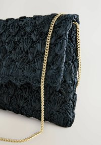 Musta teksturoitu clutch-laukku, joka on valmistettu kootusta materiaalista ja varustettu kultaketjulla. Laukussa on läppä suljenta ja pehmeä, poimutettu pinta.