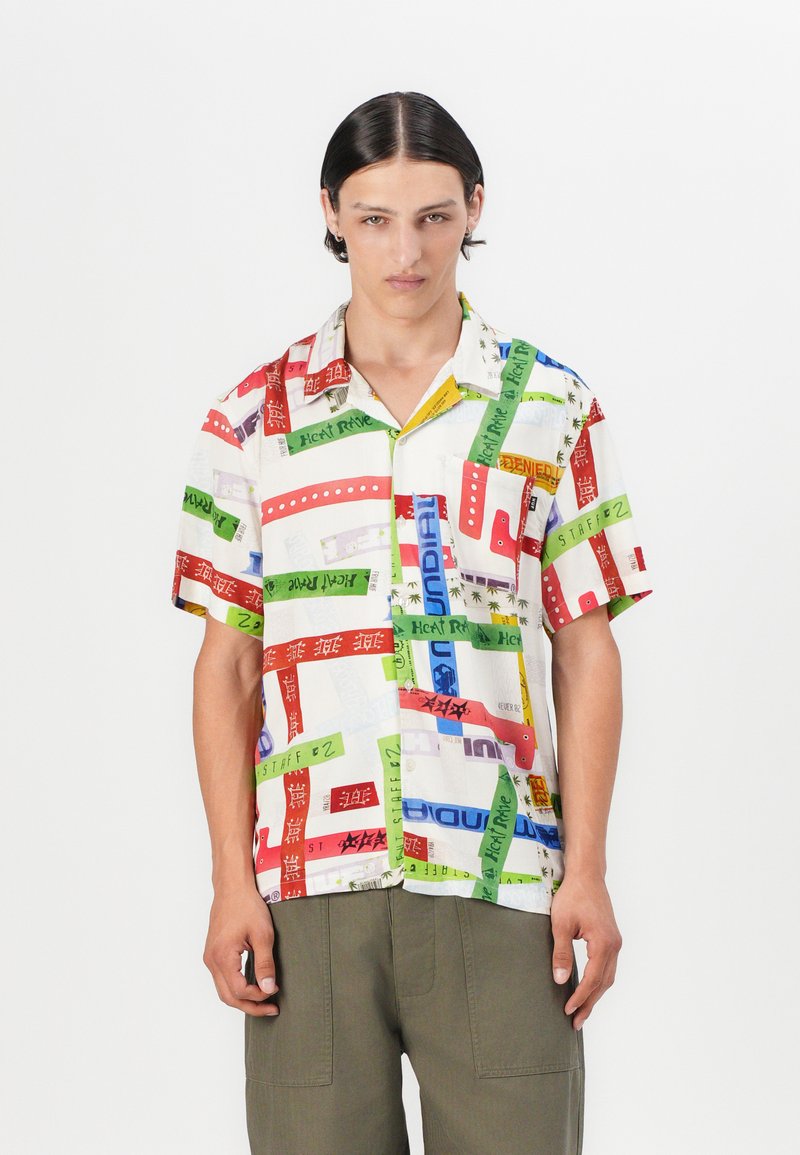 Short-sleeve button-up shirt featuring a multicolored patchwork design with various text, in white fabric with a relaxed fit.