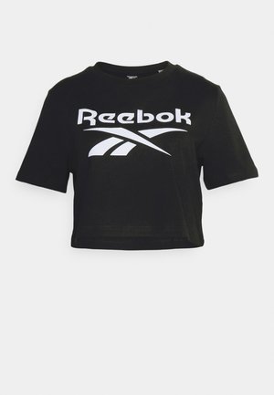 Čierne skrátené tričko vyrobené z bavlny, s výrazným bielym logom Reebok na prednej strane, krátkymi rukávmi a okrúhlym výstrihom.