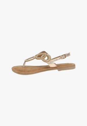 Flat thong sandal with a rose gold metallic finish, suede insole, and circular rhinestone accents. Features an adjustable ankle strap.