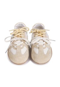 Beige suede sneakers with white leather accents, round toe, and flat soles. Features beige and white laces with a classic design.