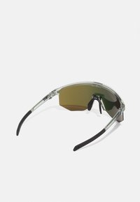 Transparente Sonnenbrille mit grün getönten Gläsern, die ein schlankes Design, eine geschwungene Form und schwarze Akzente an den Bügeln und Nasenpads aufweist.