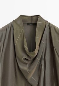Olijfgroene zijdeachtige blouse met een gedrapeerde halslijn en subtiele dunne witte rasterlijnen, label met de tekst "Massimo Dutti Made in China."