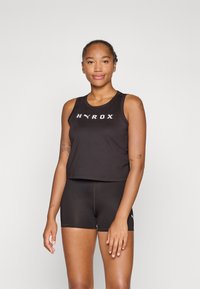 Schwarzes sportliches Crop-Top mit "HYROX"-Logo auf der Vorderseite, kombiniert mit schwarzen Shorts. Beide Kleidungsstücke zeichnen sich durch ein glattes, figurbetontes Design aus.