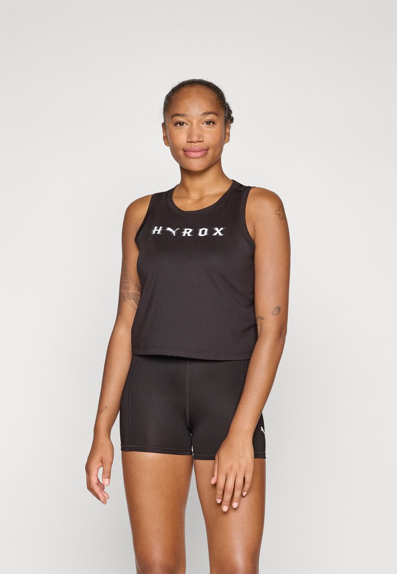 Schwarzes sportliches Crop-Top mit "HYROX"-Logo auf der Vorderseite, kombiniert mit schwarzen Shorts. Beide Kleidungsstücke zeichnen sich durch ein glattes, figurbetontes Design aus.
