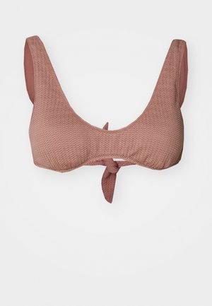 Rosa teksturert bikini topp med scoophals, brede stropper og en knute i midten foran. Har et gjentagende zigzag-mønster.