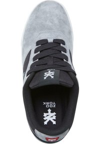 Grå semsket sneaker med svarte detaljer, runde snøringer, polstret krage og kontrasterende logo på hælen. Teksturert overdel og hvit såle.