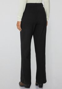Zwarte high-waisted broek met een relaxed fit, recht gesneden ontwerp, gladde textuur en geen zichtbare versieringen.