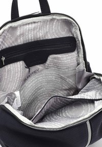 Czarny plecak z perforowaną teksturą, otwarty zamek błyskawiczny ukazujący szare wnętrze z nadrukowanym tekstem oraz wewnętrzna kieszeń na zamek.